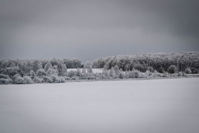 Scenic view of snow covered land against sky