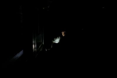 Side view of person in the dark