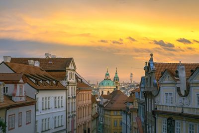 Buildings against cloudy sky at sunset