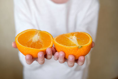 Close-up of hand holding orange fruit