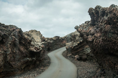 Road amidst rock formation against sky