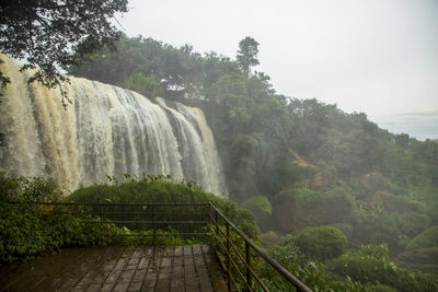 Scenic view of waterfall against sky