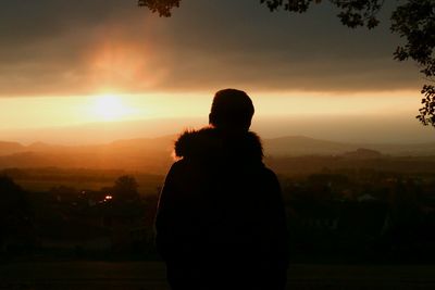 Rear view of silhouette man against sky during sunset