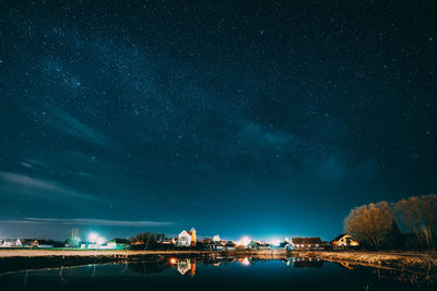 Illuminated buildings against sky at night