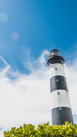 Low angle view of lighthouse by building against sky