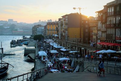 People in city against sky during sunset