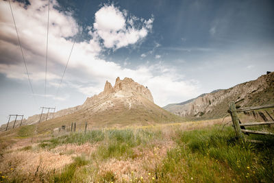 Scenic view of land and mountains against sky