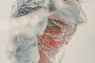 Close-up portrait of man wrapped in plastic
