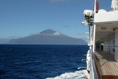 Boat sailing in sea against blue sky