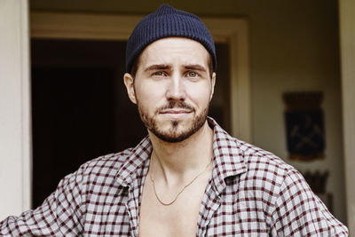 Portrait of young man wearing hat at home