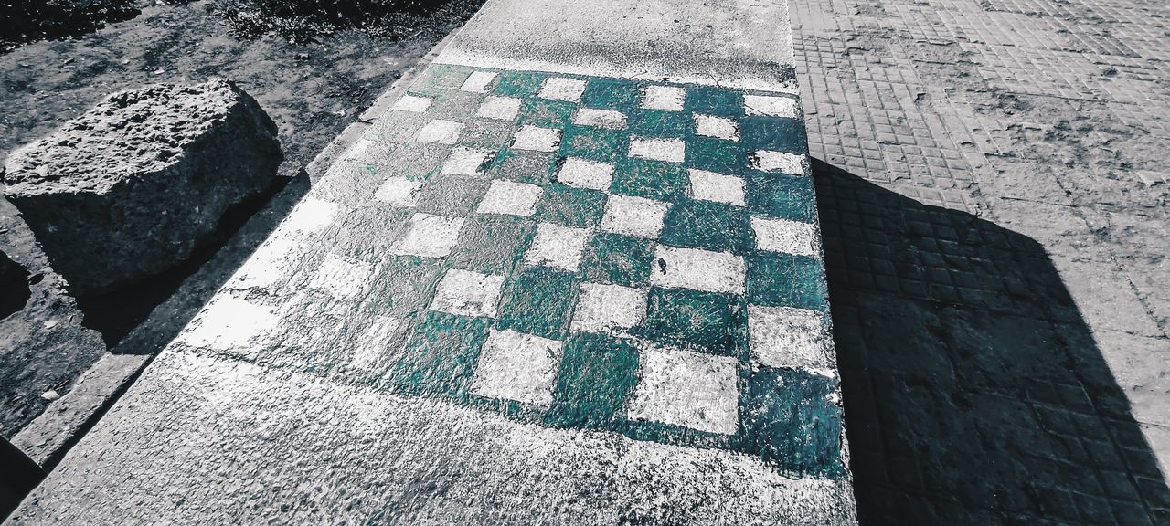 HIGH ANGLE VIEW OF TILED FLOOR WITH SHADOW ON ROCK