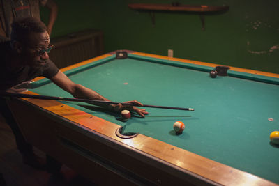 A young man playing pool.