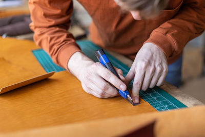 Close-up of man holding hands on table