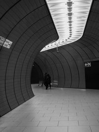 People walking in illuminated tunnel