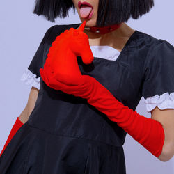 Midsection of woman standing against red background