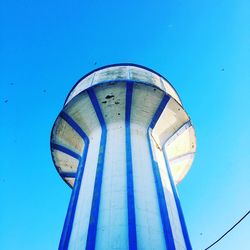 Low angle view of water tower against clear blue sky