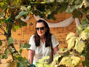 Mature woman standing amidst plants