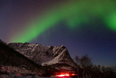 Low angle view of illuminated mountain against sky at night