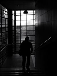 Rear view of man walking on staircase