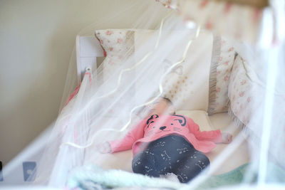 Cute baby girl sleeping in crib at home