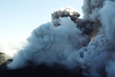 Smoke emitting from volcanic mountain against sky
