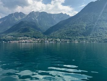 Scenic view of lake by mountains against sky