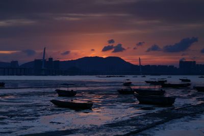 Boats in sea at sunset