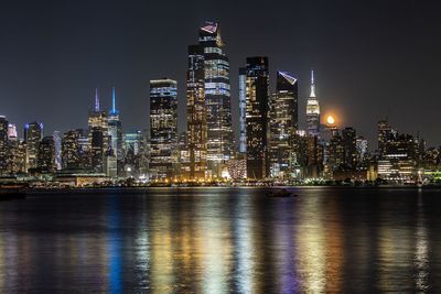 Illuminated buildings against sky at night