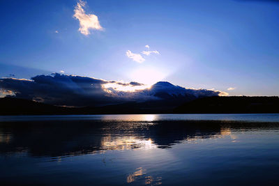 Scenic view of lake by mountains against sky