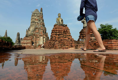 Low section of woman walking towards temple