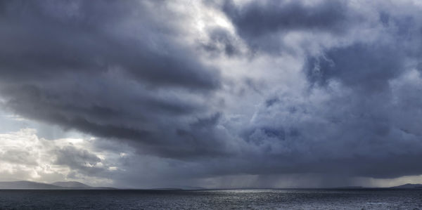 Scenic view of sea against storm clouds