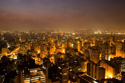 Illuminated cityscape against sky at night