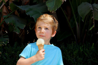 The boy with the sly gaze pressed his lips together. a five-year-old boy with ice cream in his hand.