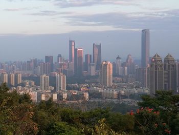 View of cityscape against cloudy sky