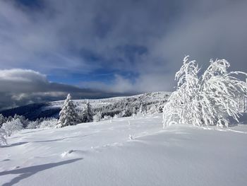 Snow covered landscape against sky