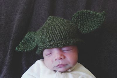 Close-up of cute baby sleeping with knit hat on bed