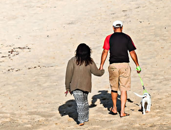 Rear view of women walking on beach