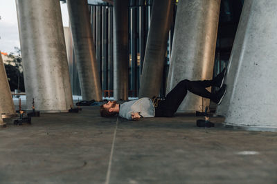 Man sleeping on street by columns