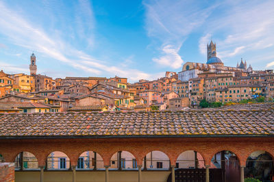 Buildings in city against cloudy sky