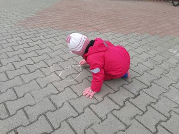 The child draws on the ground. girl 4 years old draws on the street.