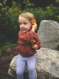 Portrait of cute girl standing on rock