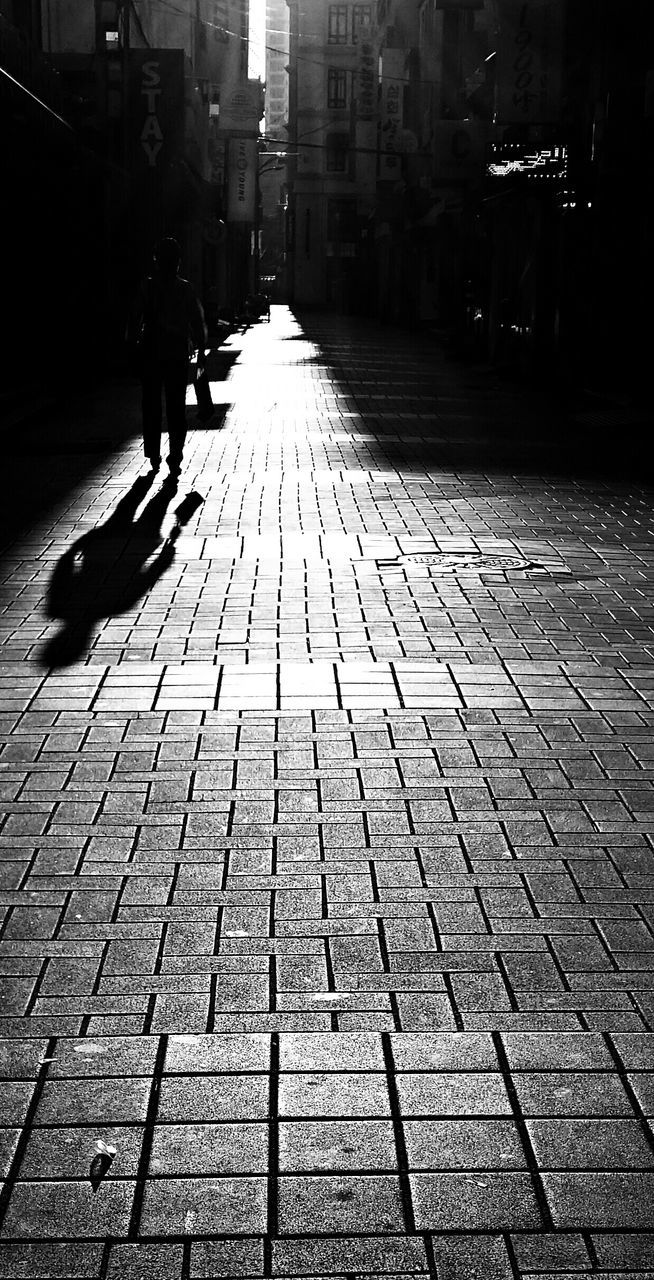 the way forward, cobblestone, building exterior, architecture, built structure, diminishing perspective, paving stone, street, city, footpath, vanishing point, walkway, shadow, pavement, sunlight, walking, outdoors, sidewalk, incidental people, pathway