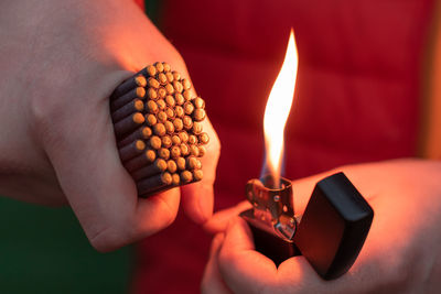 Close-up of person holding burning candle