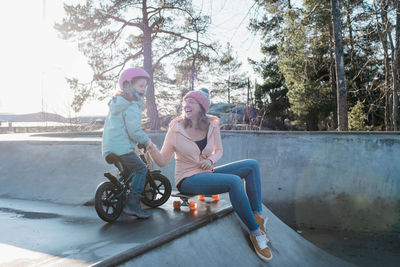 Mom and daughter playing and laughing in a skatepark in the sun