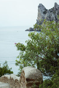 Scenic view of rocks by sea against sky