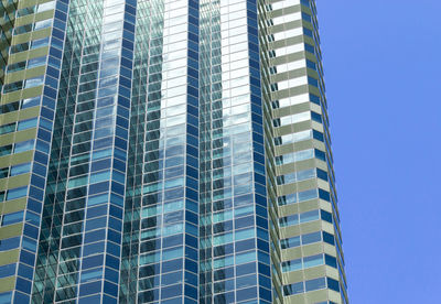 Low angle view of modern buildings against blue sky