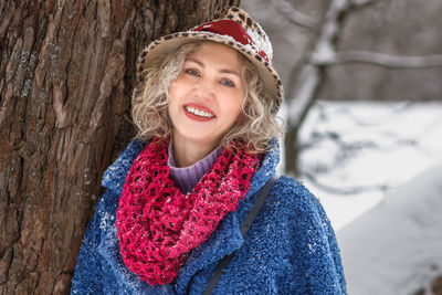 Portrait of young woman standing on tree