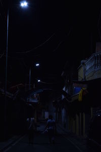 People walking on illuminated road at night