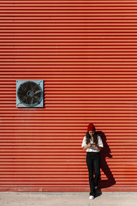 Young woman using mobile phone on footpath