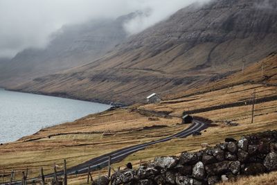 Scenic view of road by mountains against sky